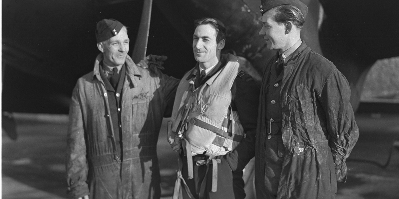 The members of RCAF ground crew are just as proud of their kites as are men who fly them. Shown above are two of the ground crew who have in their care a Mosquito Intruder and the man who flies it. Left to right: Cpl. J.L. Jones, F/L C. Scherf, and LAC R. W. Weighill. They are members of a Canadian Squadron commanded by W/C D.C.S. MacDonald. Janury 21st, 1944 (Source: Royal Canadian Air Force Museum - Researcher: Bill Nurse)