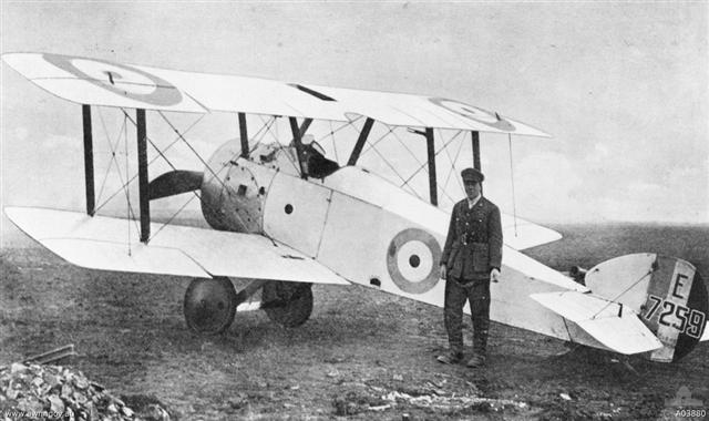 Captain G. F. Malley MC, AFC, No. 4 Squadron, AFC standing next to an all white Sopwith Camel F.1. 