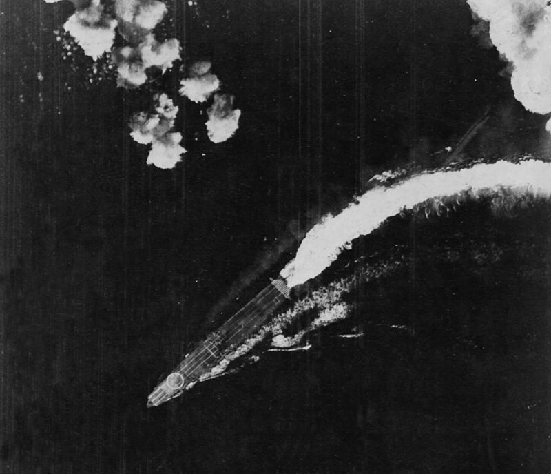 The Japanese aircraft carrier Hiryu maneuvers to avoid bombs dropped by USAAF Boeing B-17E Flying Fortress bombers during the Battle of Midway, shortly after 0800 hrs, on 4 June 1942. Note the big hinomaru identification mark on the bow, the Katakana identification character 